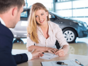 Persona firmando contrato de préstamo para comprar un auto