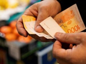 Manos contando dinero en un mercado, representando ingresos y consumo de la clase media Argentina en 2025