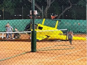 Helicóptero caído sobre una cancha de tenis durante un operativo de emergencia.