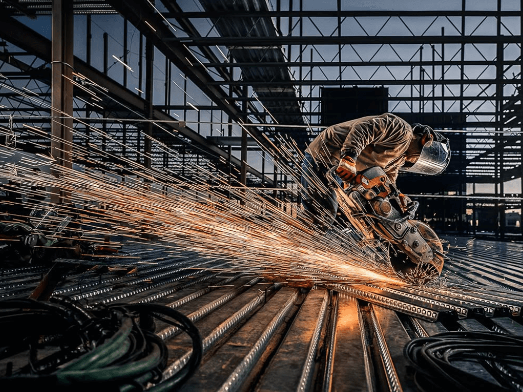 Trabajador industrial cortando acero en una obra en Argentina.