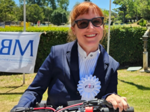 Pilar Mujica sonriendo con la escarapela de la Federación Ecuestre Internacional tras ganar la medalla dorada.