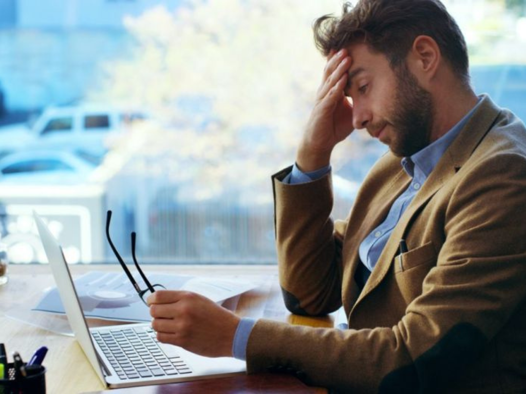 Trabajador cansado frente a la computadora sin vacaciones en Argentina.