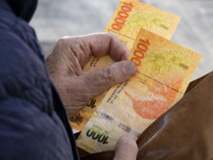 Persona contando dinero en efectivo correspondiente a los cobros de ANSES febrero 2026.