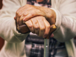 Manos de una persona mayor sobre un bastón, representando a los jubilados que cobrarán el bono de ANSES en marzo.