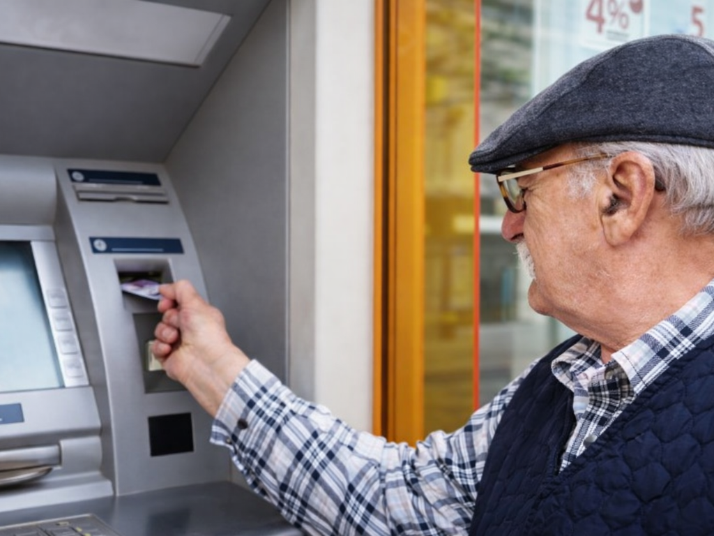 Jubilado utilizando un cajero automático para cobrar sus haberes de ANSES en febrero.
