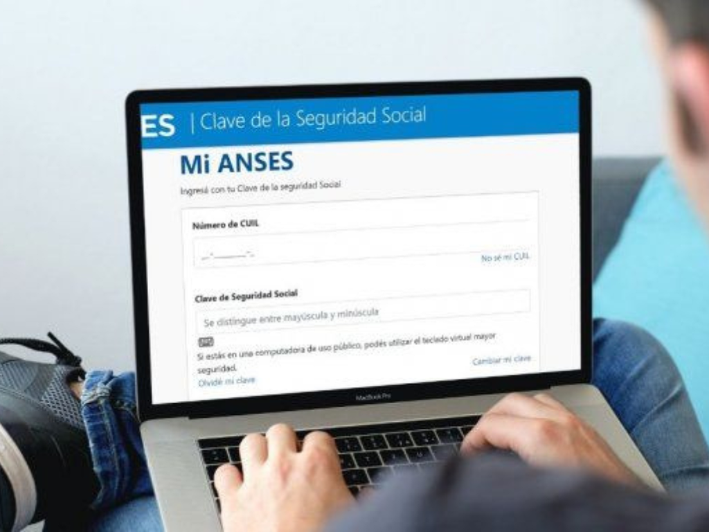 Trabajador desde su hogar accediendo a la plataforma de ANSES con su computadora para tramitar la ayuda económica por desempleo.