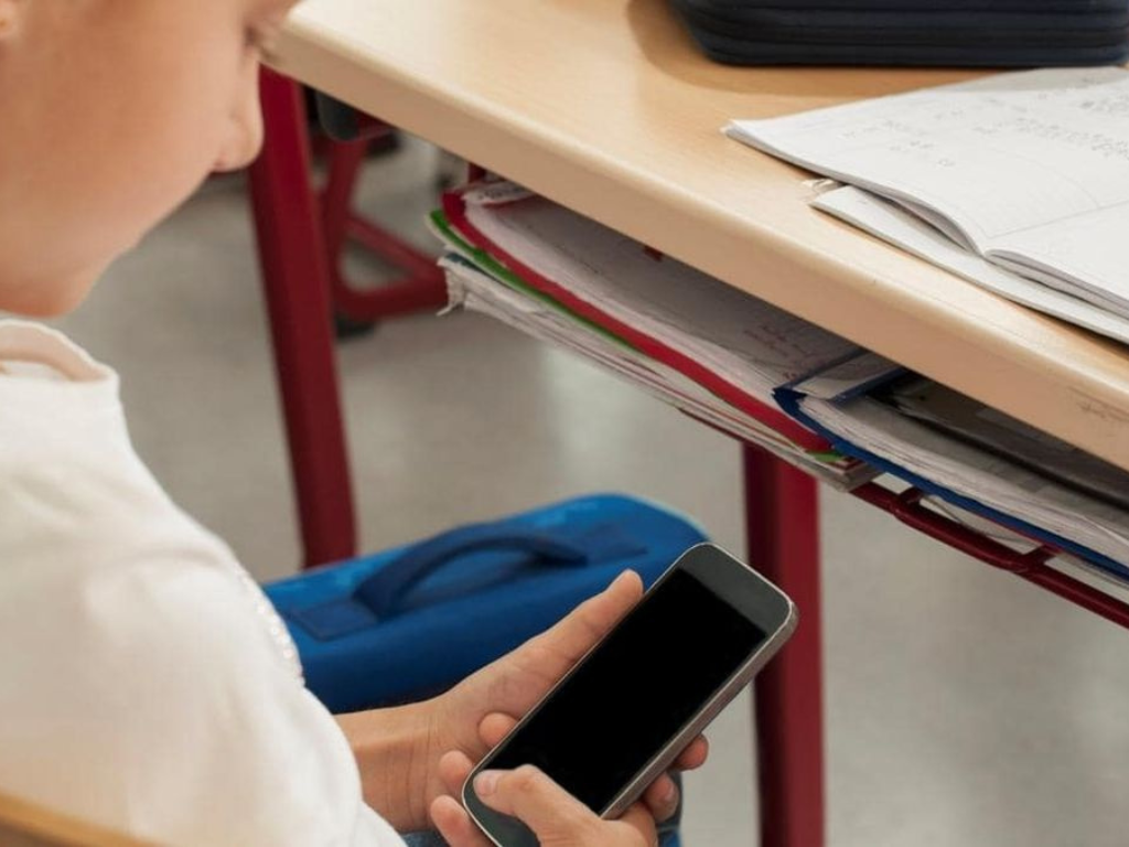 Estudiante de primaria utilizando un celular en el aula bajo la nueva prohibición en Santa Fe.