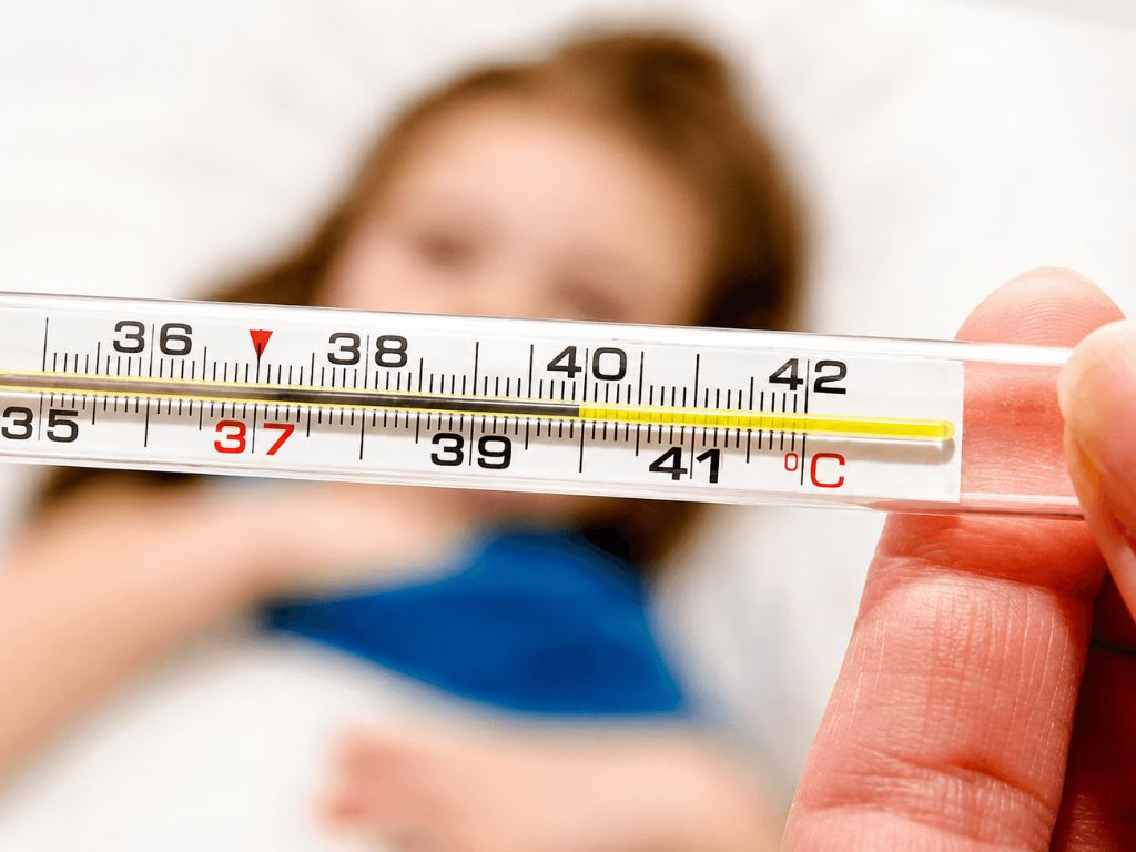 Madre controlando fiebre a su hijo, uno de los principales sintomas de meningitis