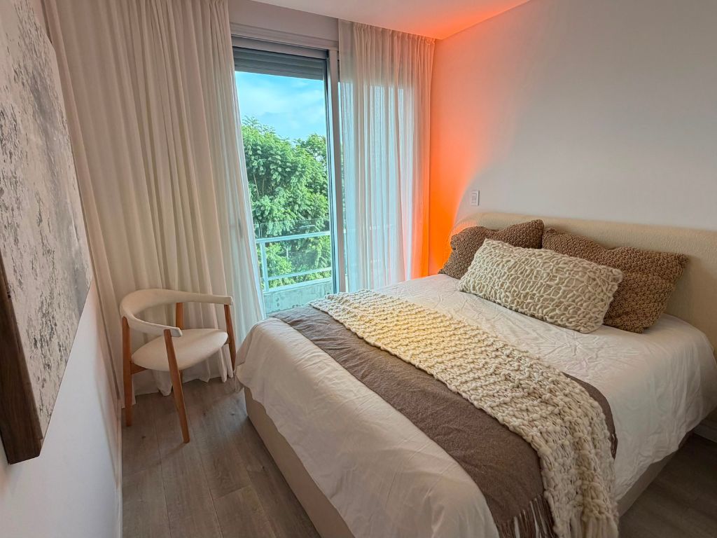 Vista del dormitorio principal con diseño cálido y funcional en el departamento modelo de MiraRío