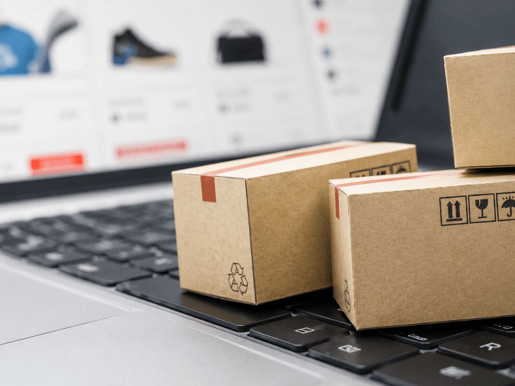 Paquetes sobre una computadora portátil que representan las compras en el exterior mediante el sistema puerta a puerta.