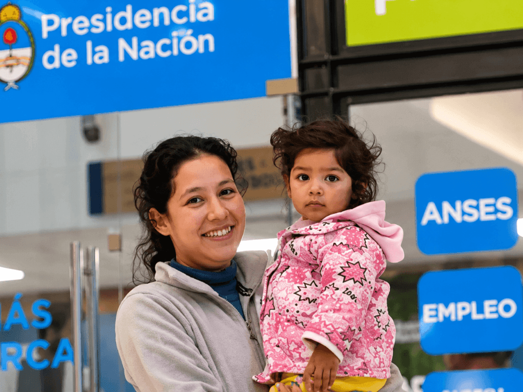 Madre con un niño frente a una oficina de ANSES, en una nota sobre la presentación de la Libreta AUH para cobrar el dinero retenido